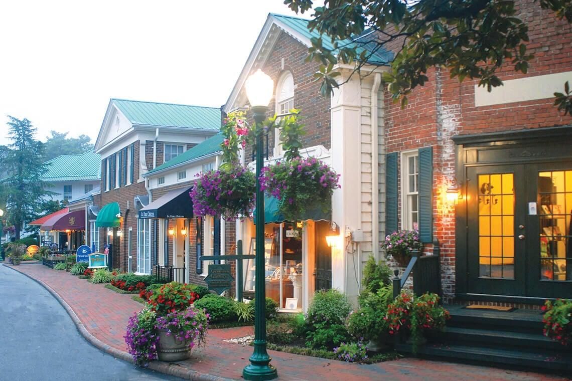 Brick storefronts and flower baskets along a street in the Village of Pinehurst